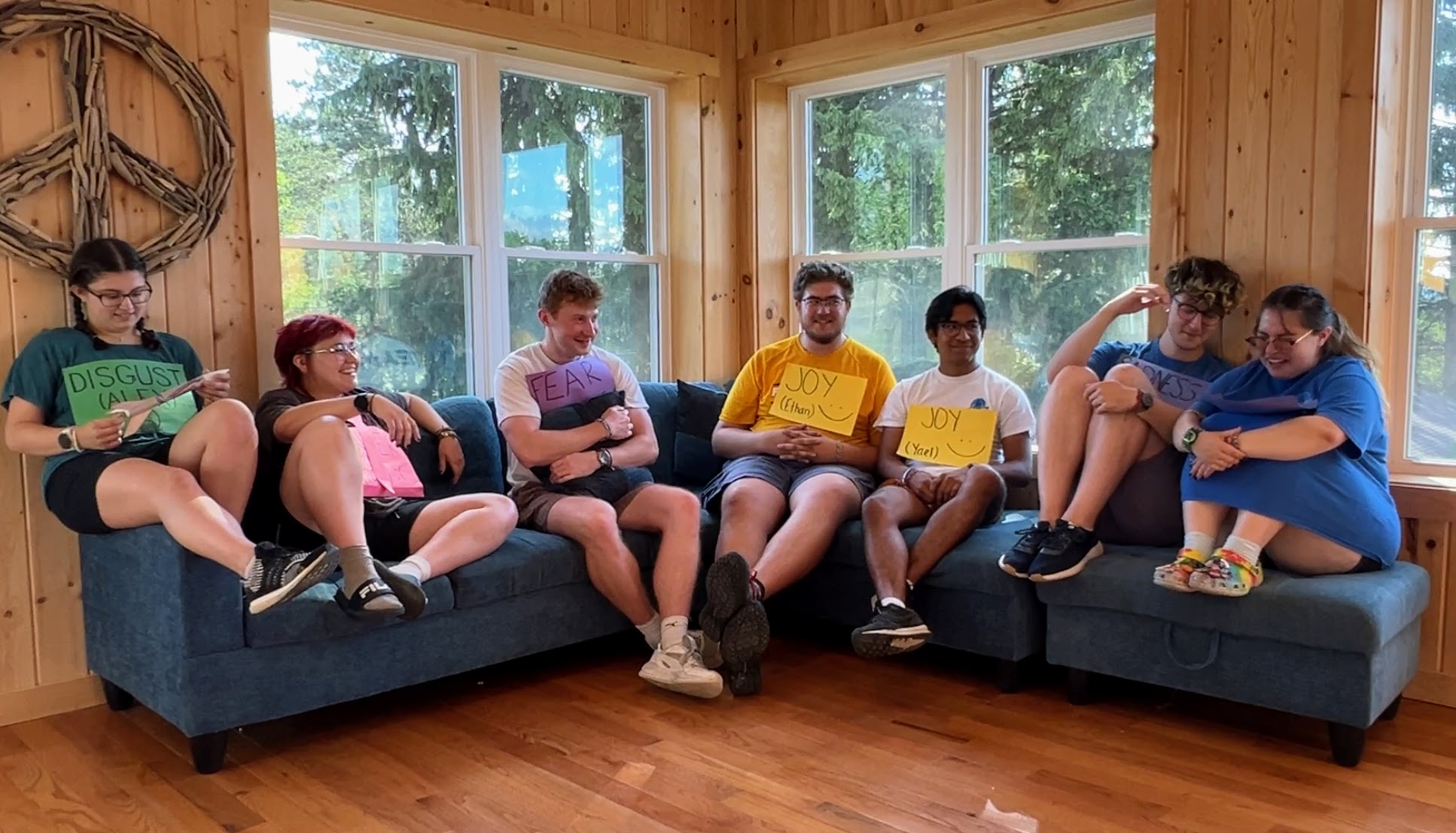 Camp staff on a cabin sofa, dressed as Inside Out emotions