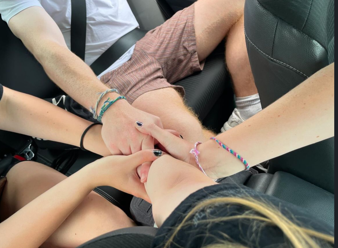 Friends stacking hands together in a car